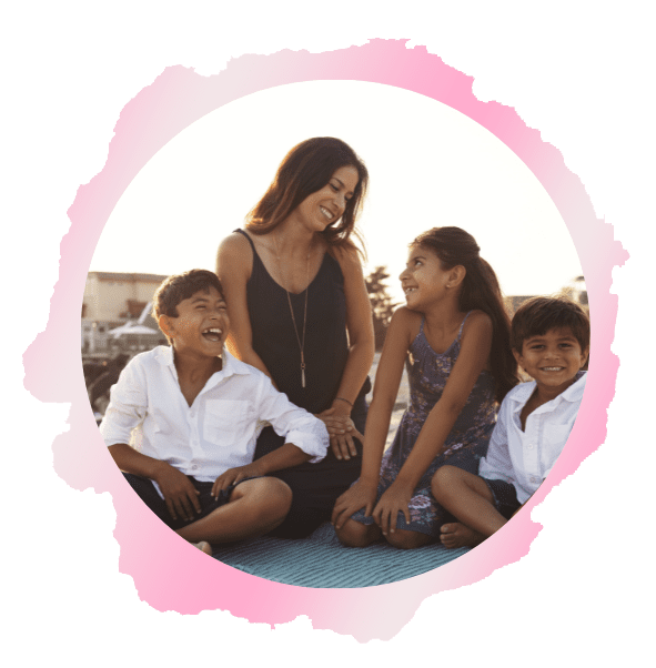 A woman and two children sitting on the ground.