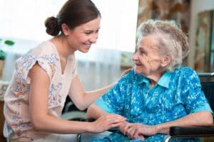 A woman holding hands with an older person.