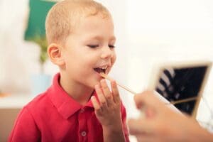 A child is eating something from a spoon.